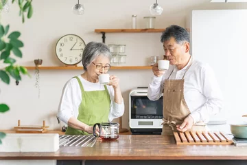  キッチンでコーヒーを飲むアジア人高齢者夫婦（笑顔）  © buritora