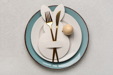 Beautiful table setting with Easter egg, paper bunny and cutlery on grey background