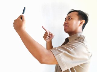 Smiling government employee showing smartphone screen. A young Asian civil servant wearing a khaki uniform.