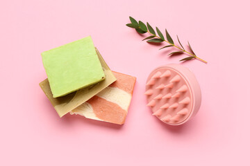 Hair scalp massager with shampoo bars on pink background