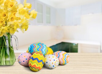 Easter eggs and yellow flower on room background.