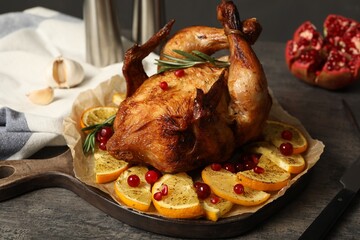Baked chicken with orange slices on grey table