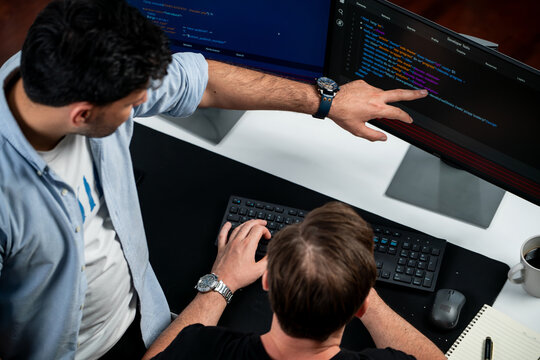 IT developers discussing online software development information on pc screen, creating program coding for latest version application on website. Concept of brainstorming firmware updated. Sellable.