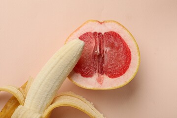 Banana and half of grapefruit on beige background, top view. Sex concept
