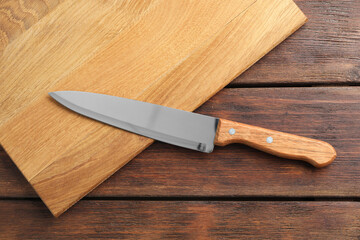 One sharp knife and board on wooden table, top view