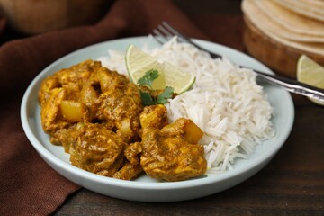 Delicious chicken curry with rice on wooden table, closeup