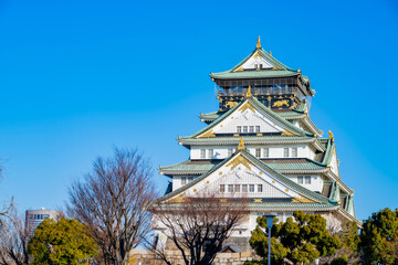 Fototapeta premium Landscape view Osaka's landmark Osaka Castle castle tower that shines in the blue sky, Osaka Japan.