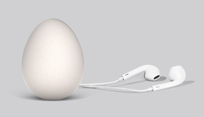 Fresh egg with headphones and cord on gray background. Creative music emotion concept.
