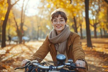 A beaming woman rides her bicycle through the colorful autumn trees, her smile reflecting the joy of the season and the freedom of the open road