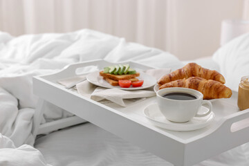 Good morning. Tray with tasty breakfast on bed at home