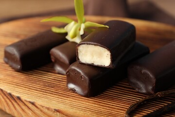 Glazed vanilla curd cheese bars served on wooden table, closeup