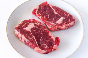 Uncooked Ribeye Steaks on a Plate