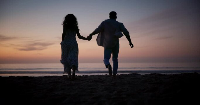 Sunset, holding hands and silhouette of couple at beach on vacation, adventure or holiday for romantic date. Love, shadow and back of people run on tropical weekend trip for valentines day together.