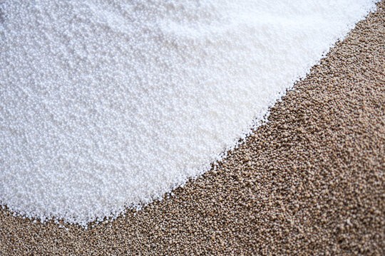Brown granular chemical fertilizer and white urea are poured to mix together
