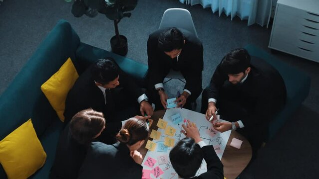 Top view of professional business people making mind map and brainstorm marketing idea by using sticky notes and writing board. Group of start up team working together to plan strategy. Directorate.