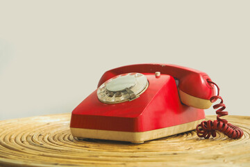 An old telephone with rotary dial, Red vintage phone. rotary telephone on table.