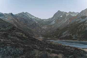 Fototapeta na wymiar The Frozen Alpine Lakes and Mountain Peaks on the Plateau At Sunset
