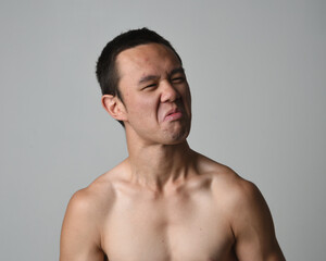Fototapeta premium Close up portrait of asian male model, expressive and exaggerated facial expressions and silly faces. Isolated on a white studio background 