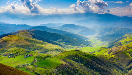 Naklejka premium panorama of beautiful countryside of romania. sunny afternoon. wonderful springtime landscape in mountains. grassy field and rolling hills. rural scenery