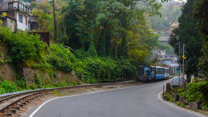 View of  city road of Darjeeling hill station with view of toy train.