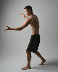 full length portrait of fit asian male model, shirtless with muscles.  gestural ti chi inspired...