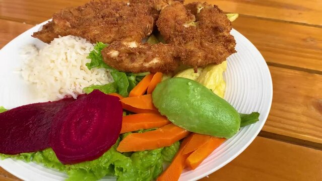 video 4k de plato de milanesa con arroz y ensalada 