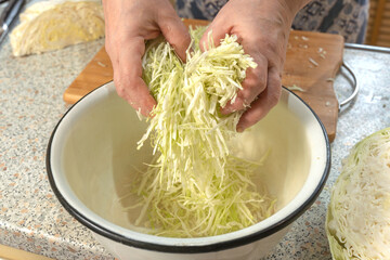 Thinly sliced white cabbage for making salad. Homemade food. Veganism and raw food diet concept.