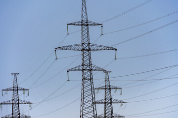 High voltage towers with sky background. Power line support with wires for electricity transmission. High voltage grid tower with wire cable at distribution station. Energy industry, energy saving