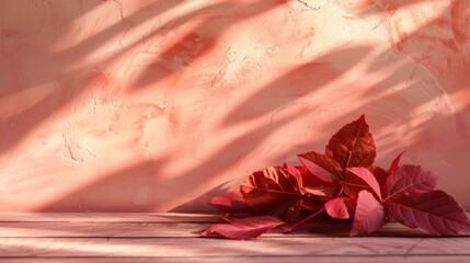 Red and pink autumn leaves cast by warm sunlight onto a wooden surface, evoking a cozy fall atmosphere.