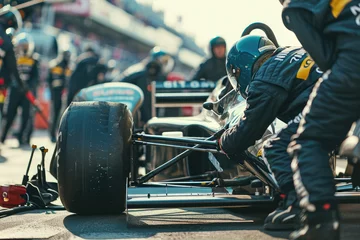 Poster close-up of a professional pit crew adjusting the suspension of a race car during a pitstop. The crew members are using wrenches, and there are other cars and spectators in the background © Formoney