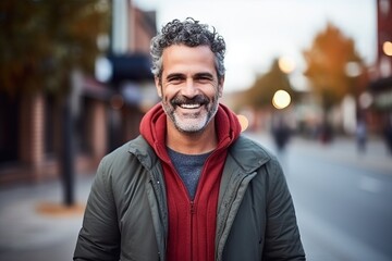 Fototapeta premium Portrait of handsome middle-aged man smiling at the camera outdoors