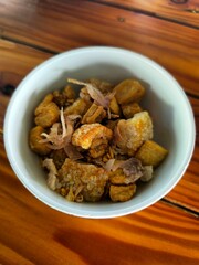 Thai Boat noodles in thicken soup added blood with Pork balls, Sliced beef and liver serve with basil and crispy fried pork skin.