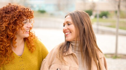 Close up of women talking happily along the street