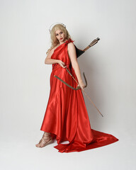 Full length portrait of  blonde model dressed as mythological fantasy goddess in flowing red silk...