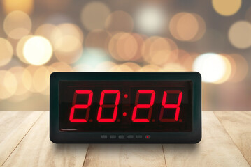 number 2024 on electric clock screen on desk with blur colorful cosy light bokeh, time signs for...