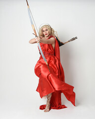 Full length portrait of  blonde model dressed as mythological fantasy goddess in flowing red silk...