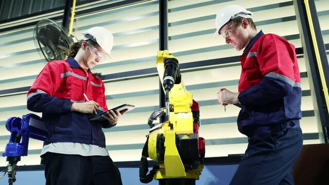 eam male engineers technicians prakong inspects service electric welding robot screwdriver check tightness structure and enter maintenance information digital tablet record information workshop.