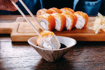 Adult man eating Japanese sushi rolls. Traditional Japanese food.
