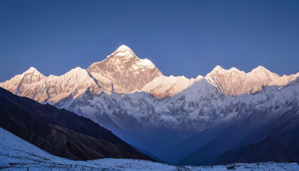 Early morning light bathes a majestic snow-covered mountain range under a clear blue sky,ai generated