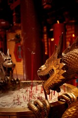 Burning prayer sticks fill the room with billowing smoke with dragon decorations on the sides at the Chinese New Year celebration. Eng An Kiong Temple, Malang, Indonesia