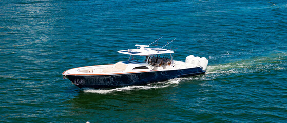 Fototapeta premium Yacht in navigation. Private boat off the beach. Summer vacation. Summertime yachting. Yacht vacation in summer. Boat trip. Travel and adventure. Motor private yacht in sea. Speedboat