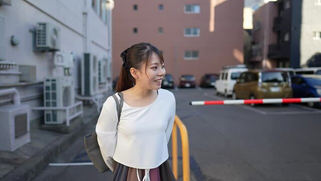 駐車場にいる２０代の日本人女性のスローモーション映像 Slow-motion video of a Japanese woman in her 20s in the parking lot