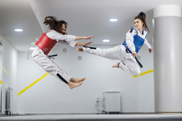 Takewodo training. Two athletes in doboks striking and kicking at training.