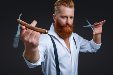 Hairdressing skills of man. Retro hairdresser holding razor and scissors isolated on black. Haircut at hairdresser man. Barber making hairstyle. Advertising for barbershop. Selective focus