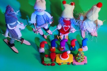 A toy train and figures of dwarfs on a green background. Christmas decorations.