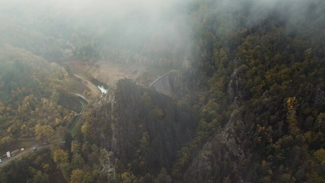 drone shot revealing gouffre d'enfer dam near saint etienne on a moody day with fog and low clouds, fance