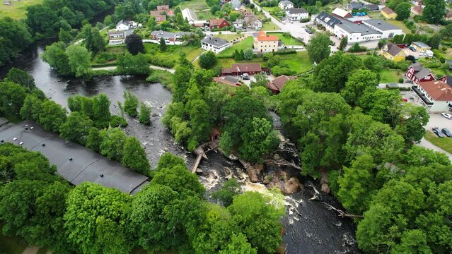 Laxens hus by morruman river in morrum, sweden with lush greenery and cascading waters, aerial view