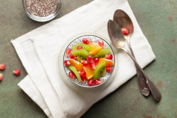 Matcha chia puddind with fruit berry salad in glass on bright background. Healthy breakfast