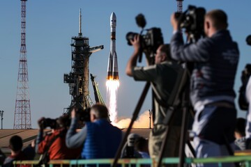 press photographers capturing rocket on launchpad