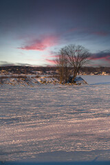 Winter view of the Quebec with a sunset on the frozen St. Lawrence river.